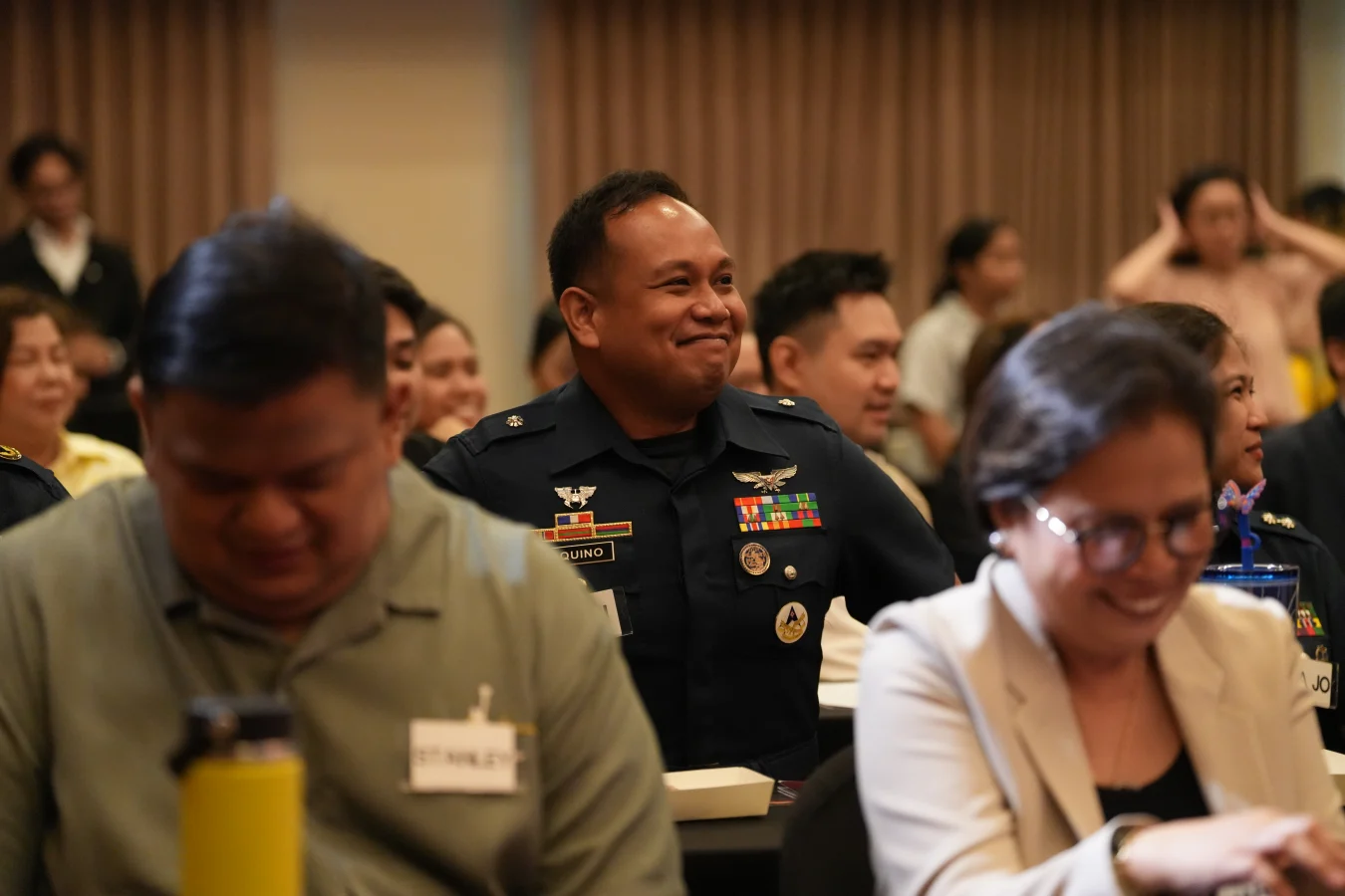 Francis Kong seated and smiling in a dark editorial portrait